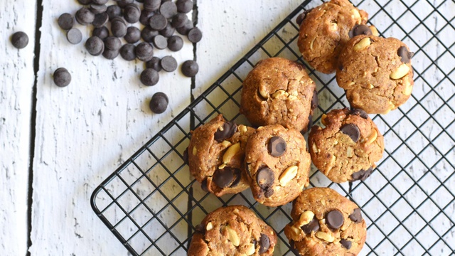 Bite sized peanut butter cookies with chocolate chips rest on wire rack