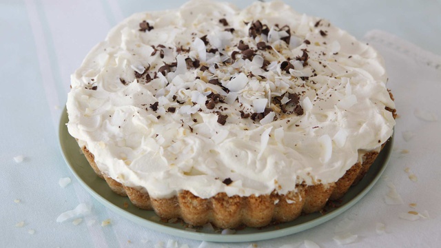 Coconut pie served with whipped cream with chocolate and coconut shavings