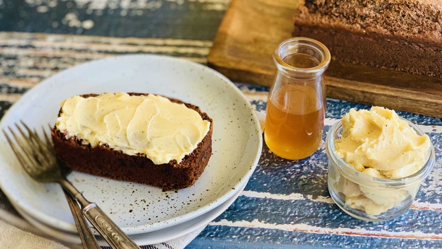 Thick slice of nutty brown date and honey loaf served with honey and whipped butter