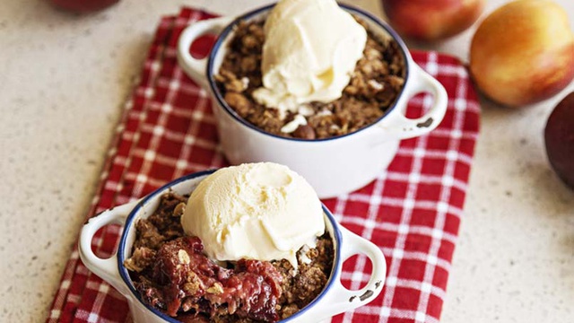 White serving pots hold roasted nectarine and plum crumble with a scoop of vanilla ice cream